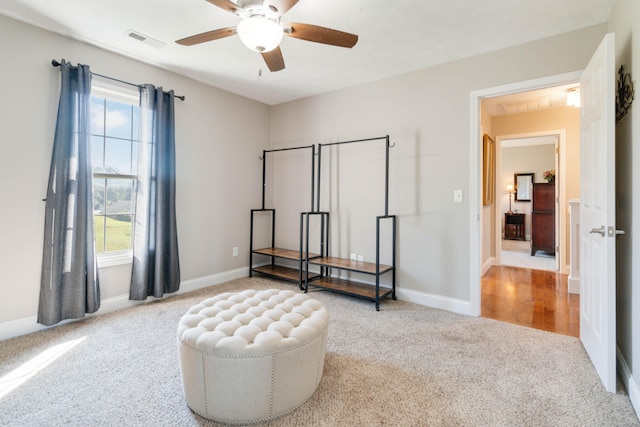 living area featuring ceiling fan and light colored carpet