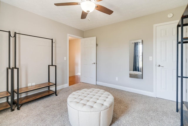 sitting room with ceiling fan and light colored carpet