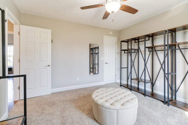 sitting room featuring ceiling fan and carpet flooring