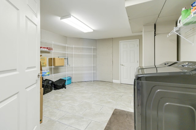 clothes washing area featuring washing machine and dryer and light tile patterned floors