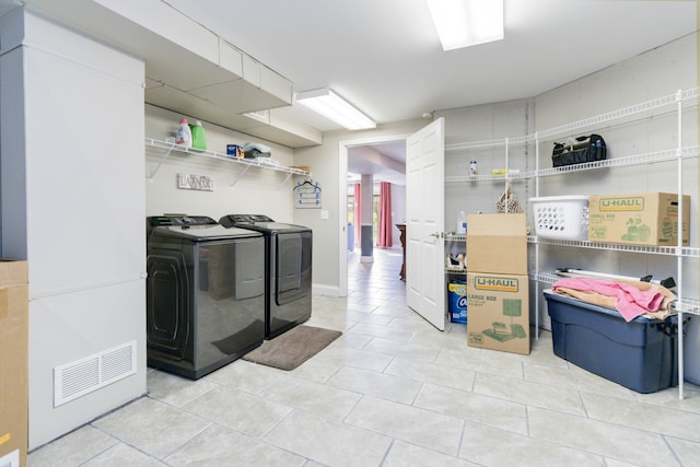 washroom with washer and clothes dryer and light tile patterned floors