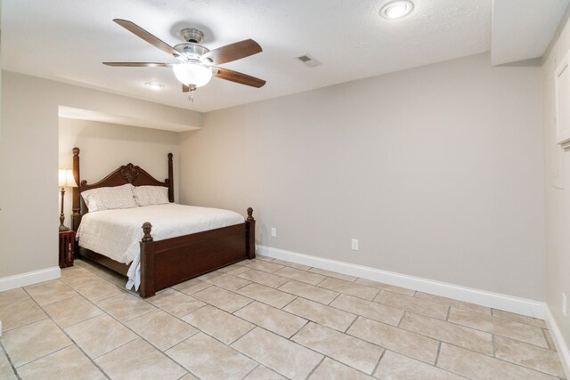 unfurnished bedroom featuring ceiling fan, light tile patterned floors, and a textured ceiling