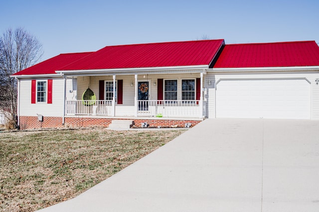 view of front of property with covered porch, a front yard, and a garage