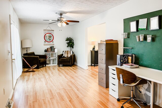 bedroom with a textured ceiling, a closet, ceiling fan, and a walk in closet