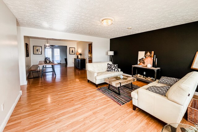 living room featuring wood-type flooring and a textured ceiling