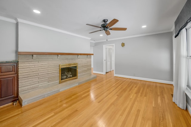 unfurnished living room with ornamental molding, light wood-type flooring, ceiling fan, and a fireplace