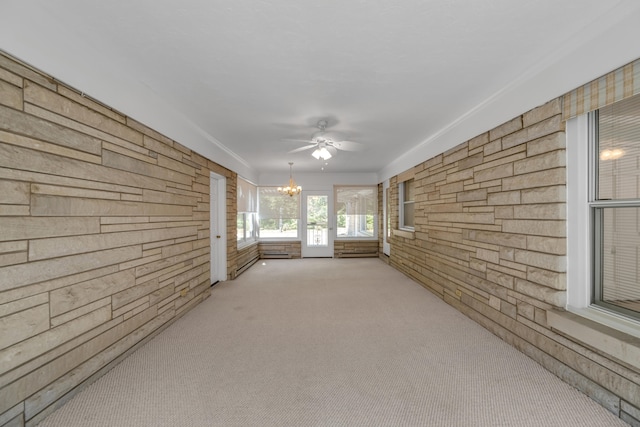 unfurnished sunroom featuring ceiling fan with notable chandelier