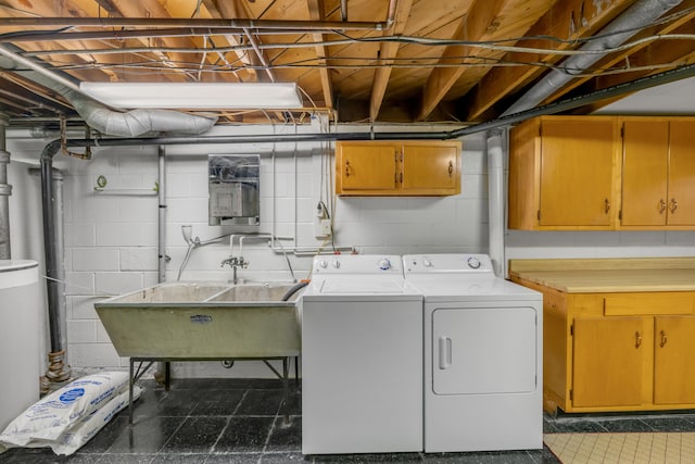 washroom with cabinets, sink, and washing machine and clothes dryer