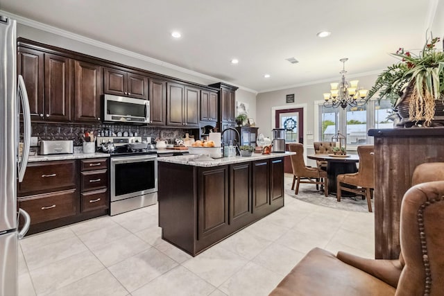 kitchen featuring pendant lighting, stainless steel appliances, ornamental molding, and a center island