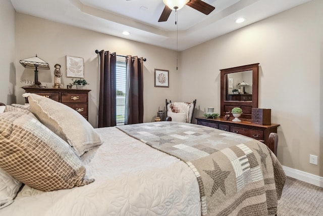 bedroom featuring a raised ceiling and ceiling fan