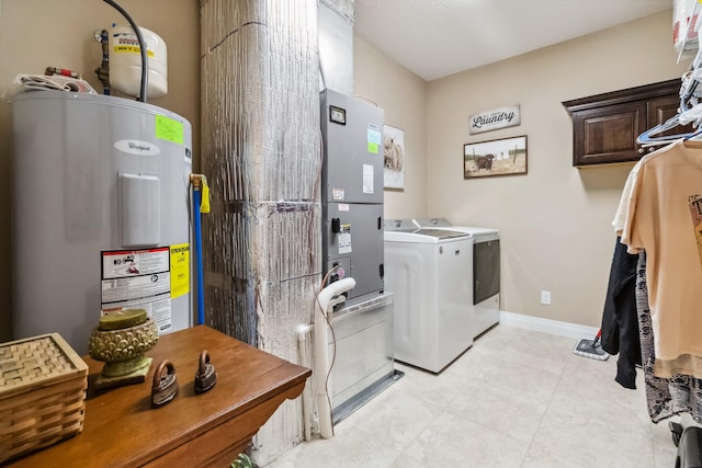 laundry room with light tile patterned floors, electric water heater, cabinets, and independent washer and dryer