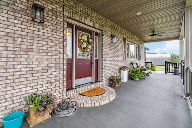 view of exterior entry featuring a porch and ceiling fan