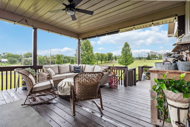 wooden terrace with ceiling fan and an outdoor hangout area