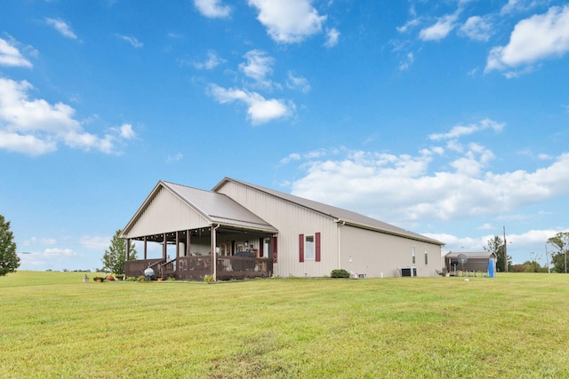 rear view of property with a sunroom, central air condition unit, and a yard