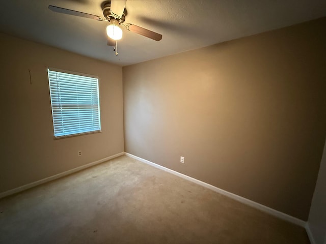 unfurnished room featuring a ceiling fan, carpet flooring, and baseboards