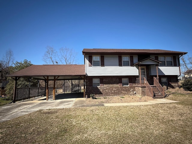 split foyer home with driveway, brick siding, and an attached carport