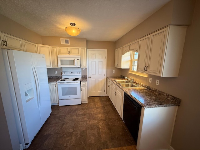 kitchen with a textured ceiling, white appliances, a sink, visible vents, and dark countertops