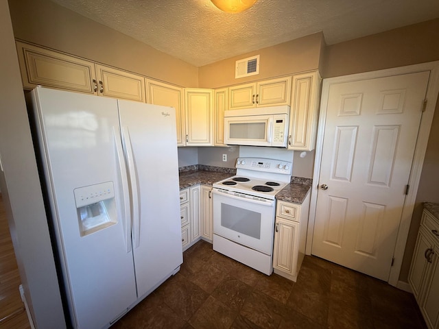 kitchen with a textured ceiling, cream cabinets, white appliances, visible vents, and dark countertops