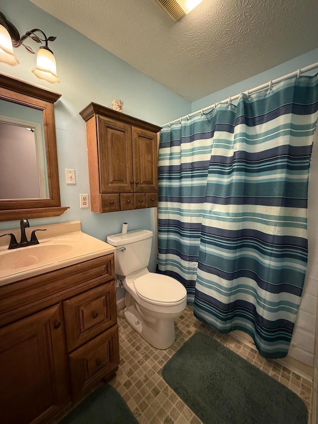 bathroom with visible vents, a shower with shower curtain, toilet, vanity, and a textured ceiling