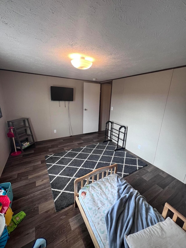 bedroom featuring dark wood-type flooring and a textured ceiling