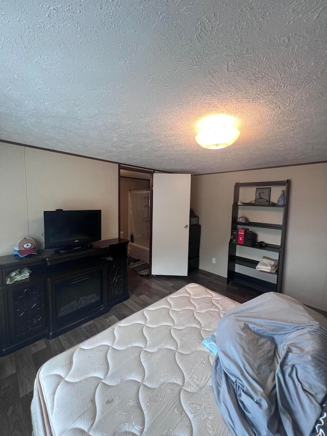 bedroom featuring a textured ceiling and dark hardwood / wood-style floors