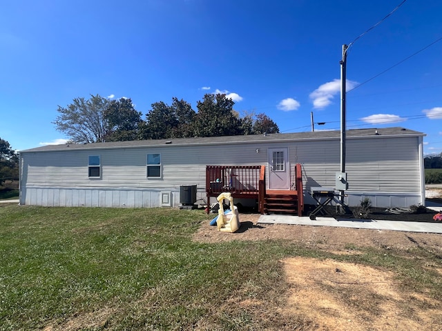 rear view of house featuring a deck, central AC unit, and a lawn