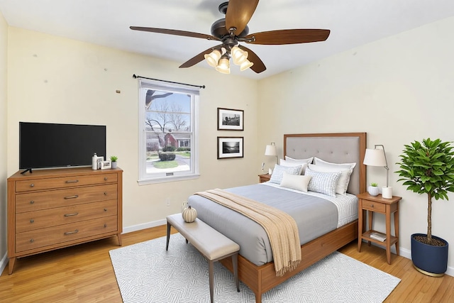 bedroom with baseboards, a ceiling fan, and light wood-style floors