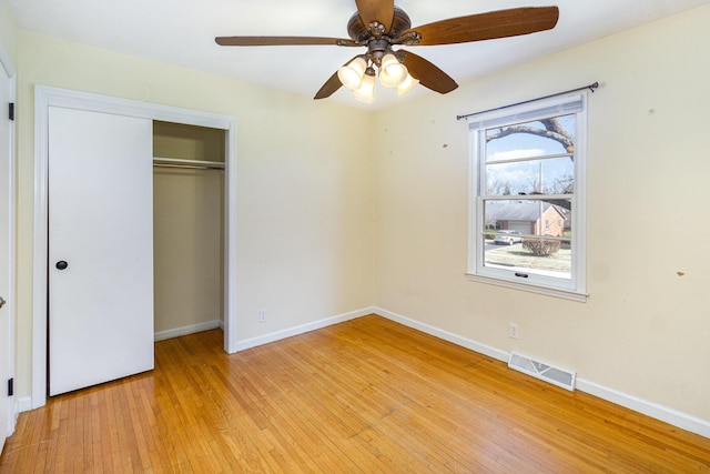 unfurnished bedroom featuring a ceiling fan, visible vents, baseboards, a closet, and light wood finished floors