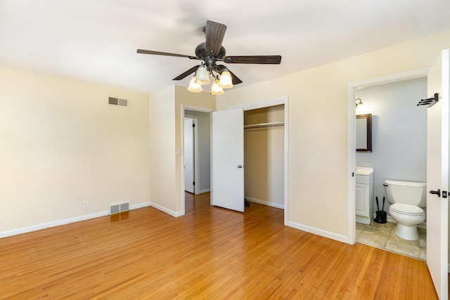 unfurnished bedroom featuring light wood-style floors, a closet, visible vents, and baseboards