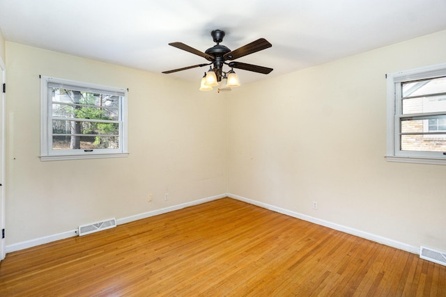 unfurnished room with light wood-style flooring, visible vents, and baseboards