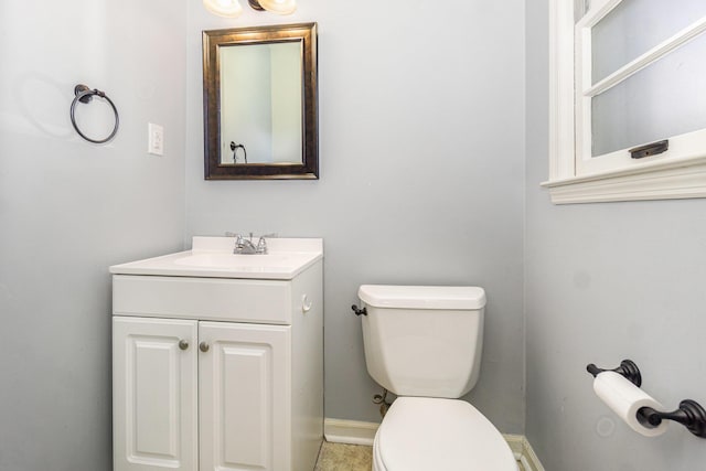 bathroom with vanity, toilet, and baseboards