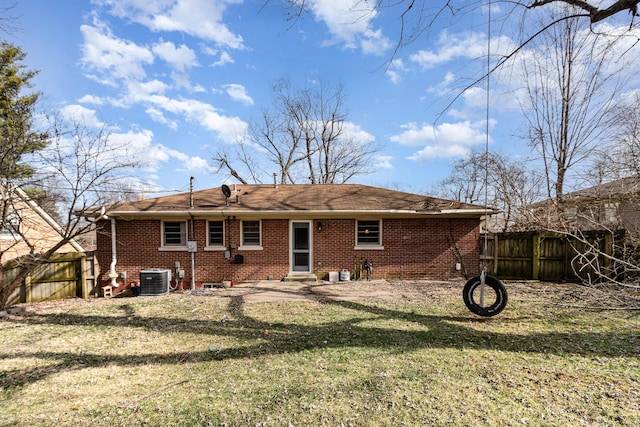 back of property featuring brick siding, a lawn, entry steps, central AC, and fence