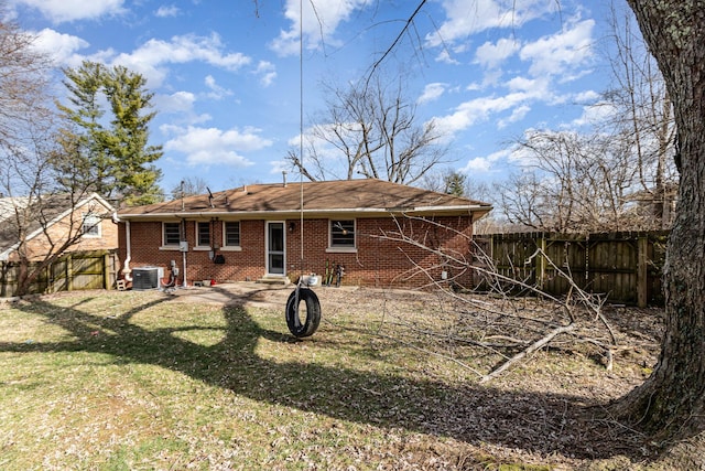 rear view of house featuring brick siding, a yard, central air condition unit, entry steps, and fence private yard