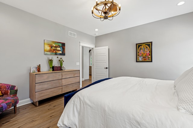 bedroom with recessed lighting, visible vents, baseboards, and wood finished floors