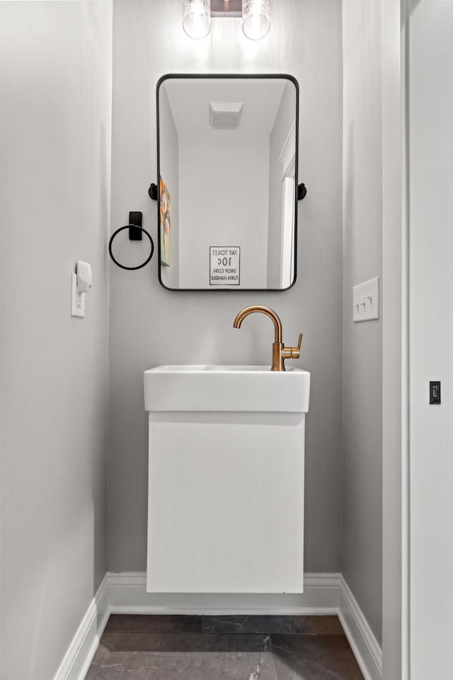 bathroom with wood finished floors, vanity, and baseboards