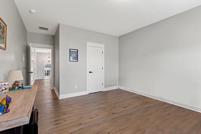 interior space with visible vents, baseboards, and dark wood-type flooring