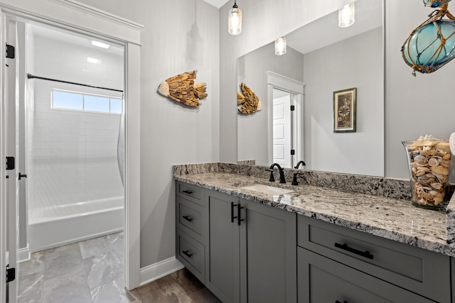 bathroom featuring shower / bathing tub combination, vanity, and baseboards