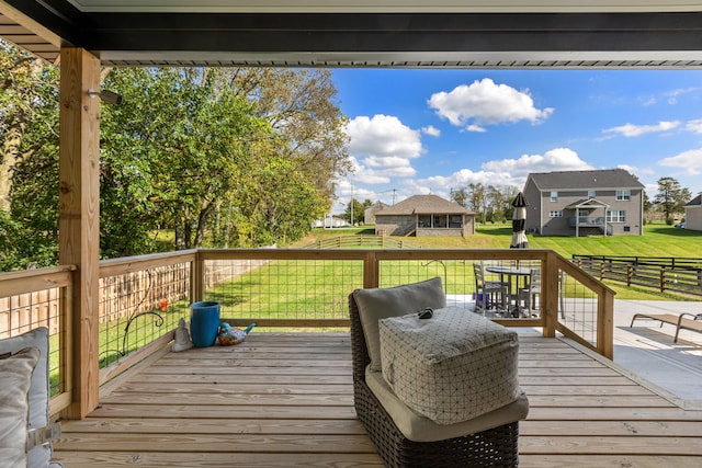 wooden terrace featuring a residential view and a lawn