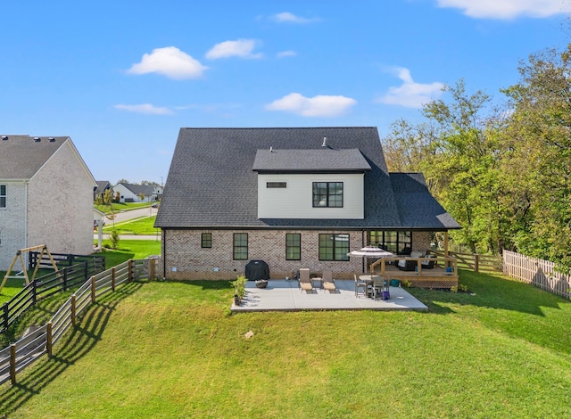 back of house featuring a fenced backyard, a yard, brick siding, and a patio