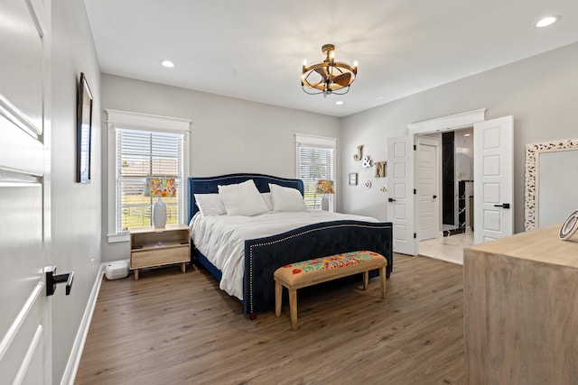 bedroom with dark wood-type flooring, recessed lighting, baseboards, and an inviting chandelier