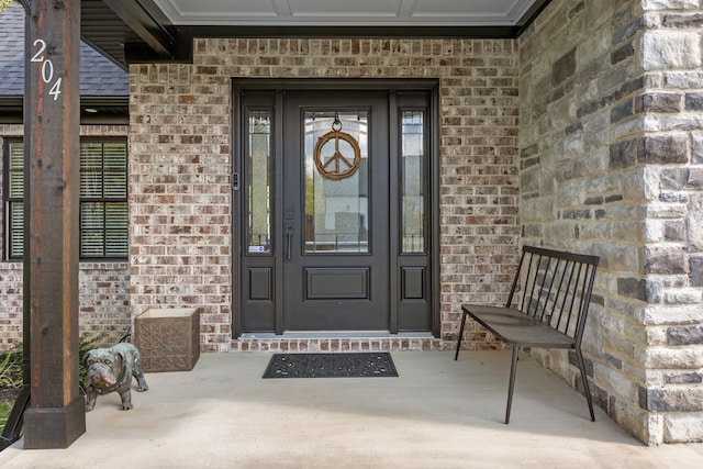 entrance to property featuring brick siding