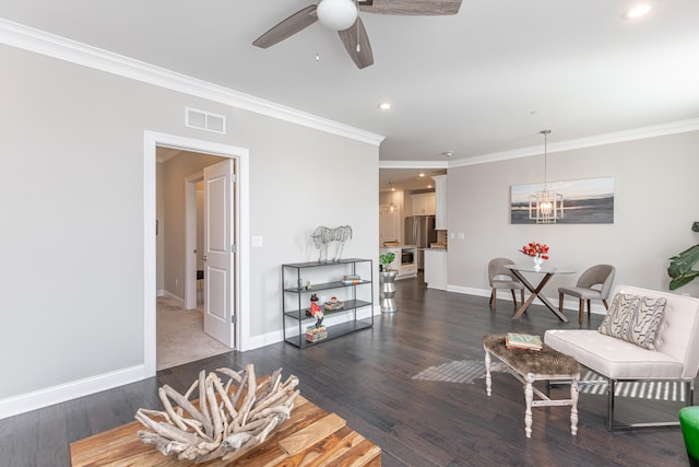 living room featuring dark hardwood / wood-style flooring, ornamental molding, and ceiling fan with notable chandelier