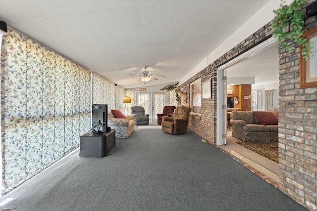 interior space with ceiling fan, carpet flooring, a textured ceiling, and vaulted ceiling