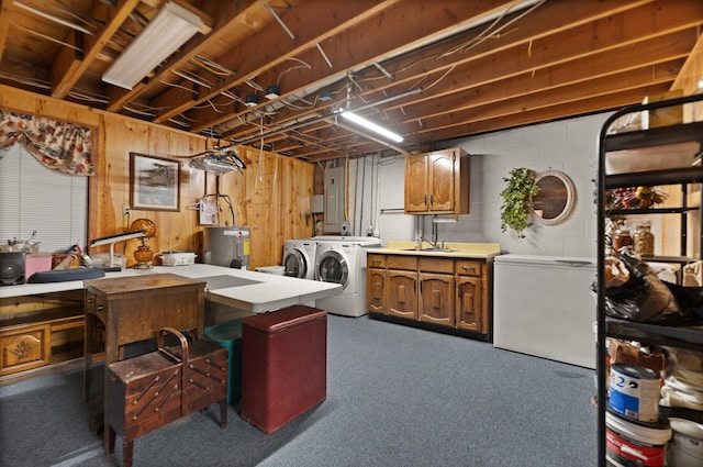 laundry area with water heater, independent washer and dryer, cabinets, electric panel, and sink