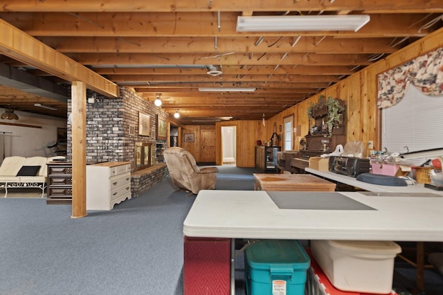 basement with carpet, wooden walls, and brick wall