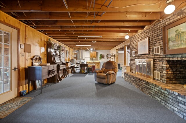 basement with a brick fireplace, brick wall, and carpet floors