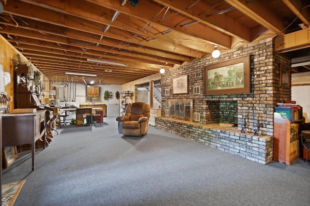 basement featuring carpet floors, a fireplace, and brick wall