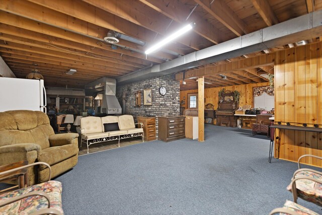 basement featuring carpet floors, wood walls, and brick wall