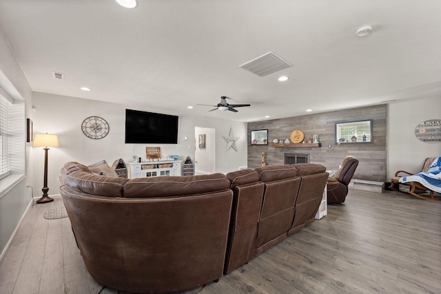 living room with ceiling fan, a fireplace, and light hardwood / wood-style flooring