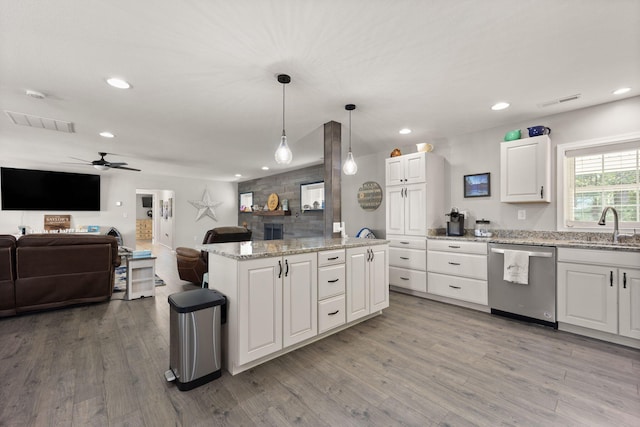 kitchen featuring white cabinetry, a kitchen island, dishwasher, light hardwood / wood-style flooring, and decorative light fixtures